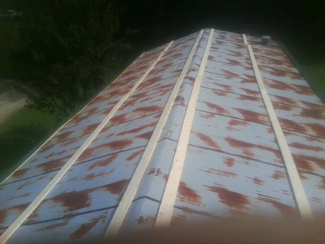 Rusted metal roof panels with new wood purlins before replacement — Storm Damage Roof Repair in Newalla by Roofing Brothers