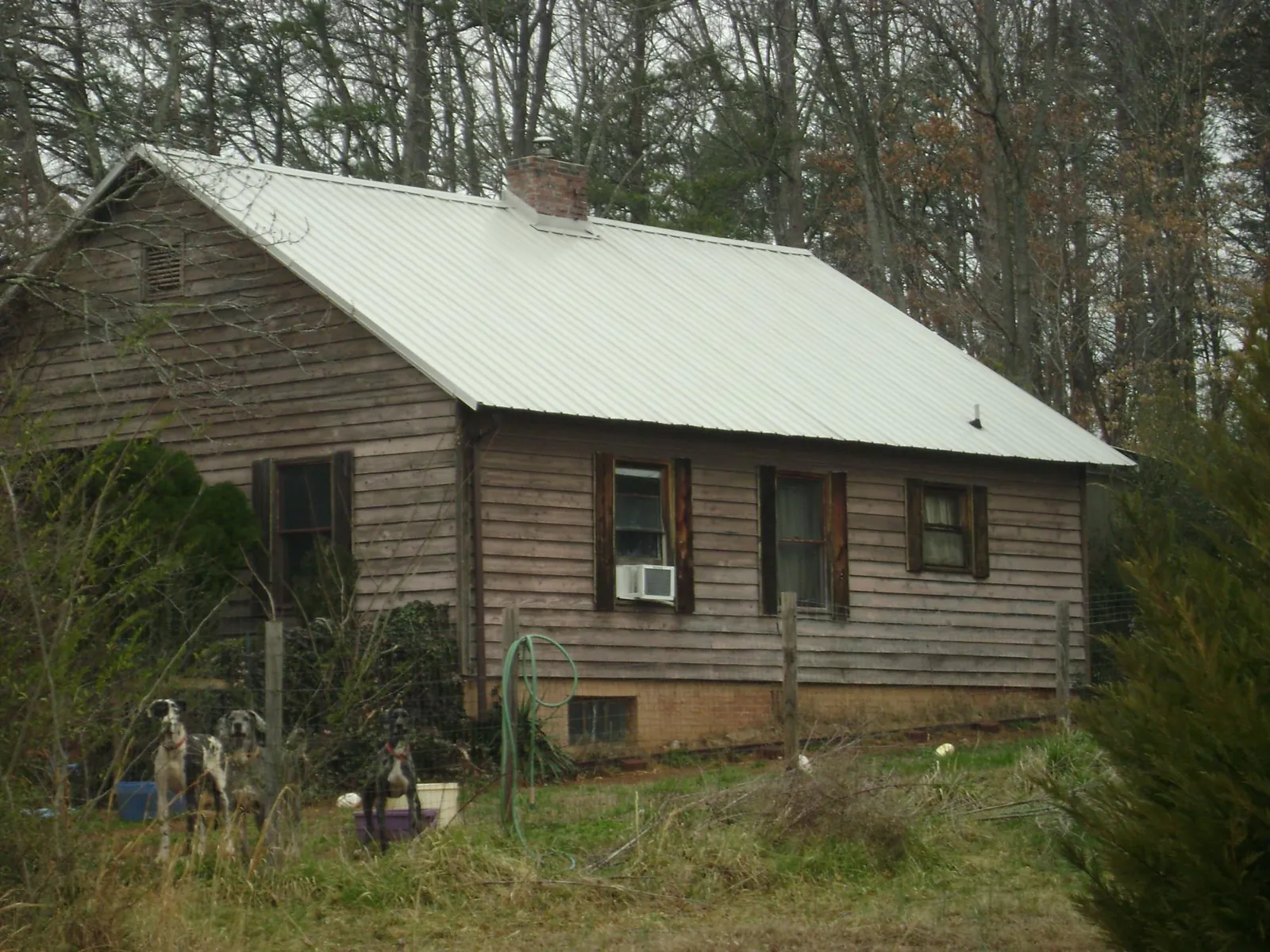 White metal roof on an old wood sided farmhouse, from a Metal Roof Installation job in Newalla